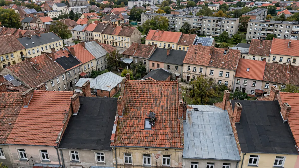 Widok z góry na dachy kamienic krytych czerwoną dachówką